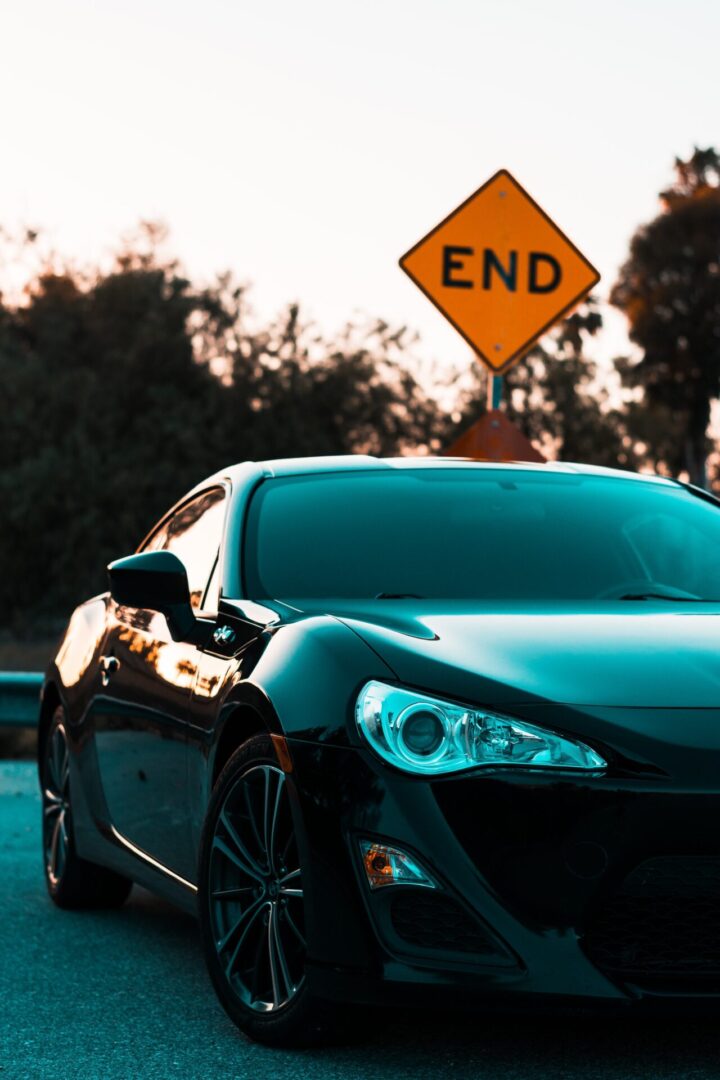 A black car parked on the side of a road.