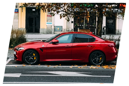 A red car parked on the side of a street.